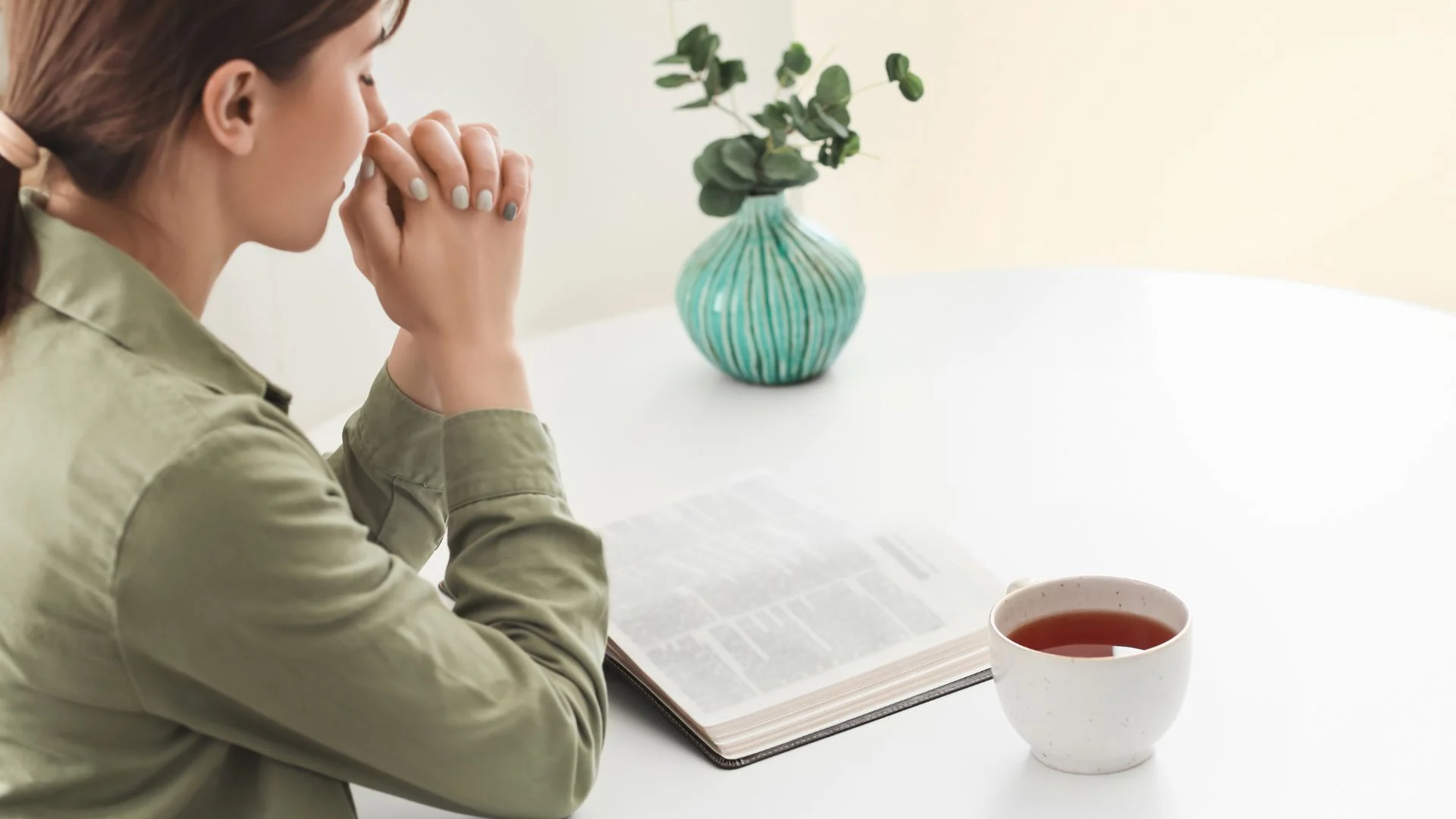 Woman sitting at a table praying