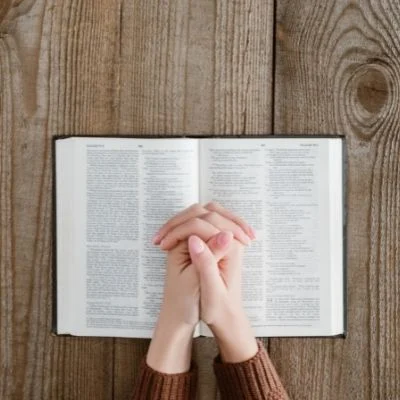 woman praying with Bible